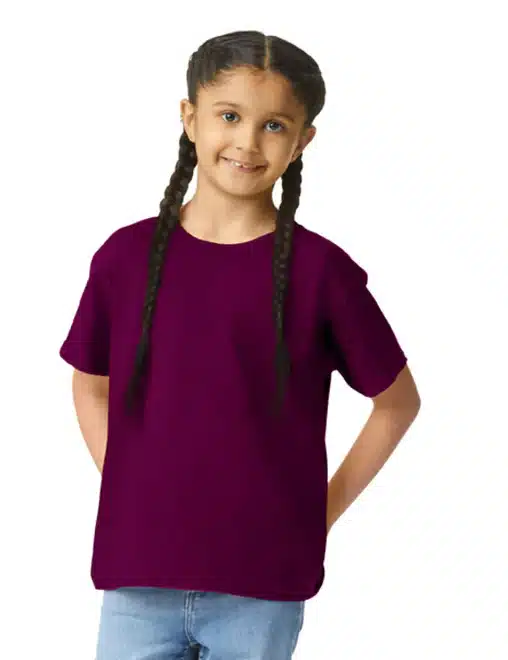 Girl in a purple t-shirt with braided pigtails smiling