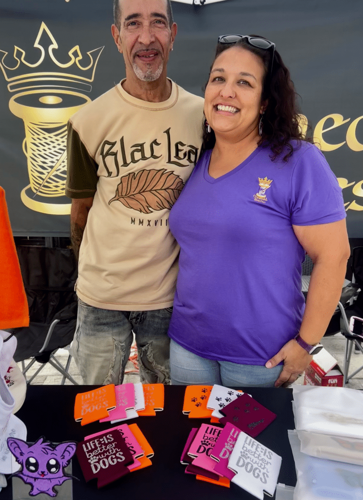 Crowned Stitches owners at embroidery booth, "Life is Better with Dogs" design.